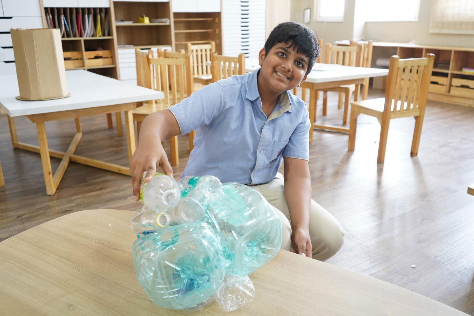 A primary student at Prometheus School is engaged in a project aimed at recycling plastic bottles.