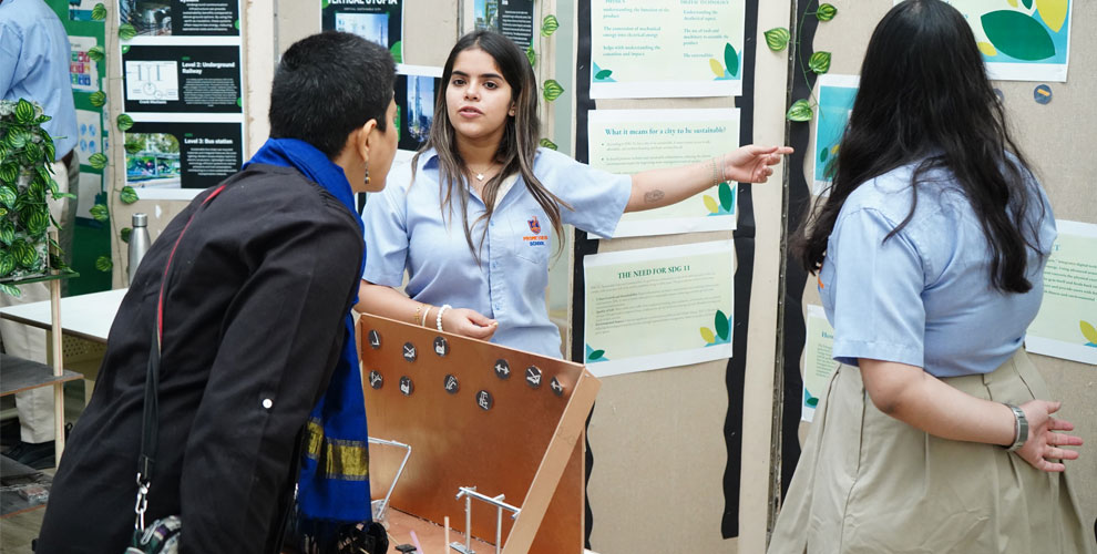 student is displaying her project to parents at Prometheus School, highlighting the school's emphasis on student-led initiatives and parental involvement