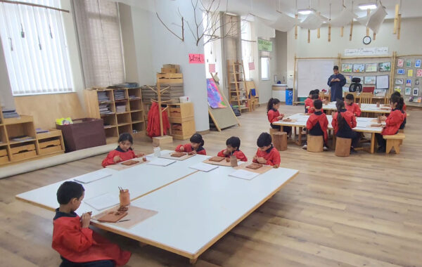 A vibrant art classroom where a group of Prometheus School students is actively engaged in creative activities, surrounded by art supplies and colourful artworks