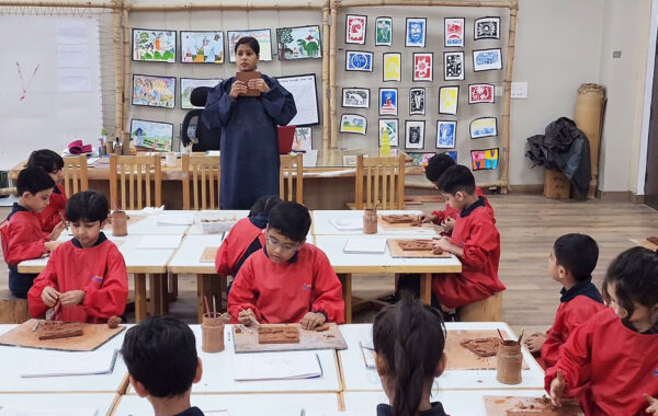 Prometheus School students attentively following their art teacher’s instructions while working on creative projects in a bright and inspiring classroom