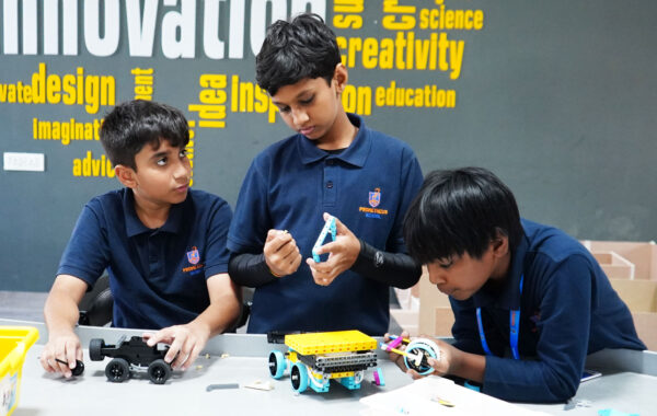 Prometheus School students working together to assemble and program a robot in the Secondary Robotics Lab