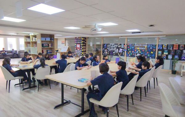 secondary students gathered in the Prometheus School library, reading books together and fostering a love for literature