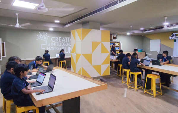 students actively working on laptops, exploring programming concepts in the Primary Robotics Lab at Prometheus School