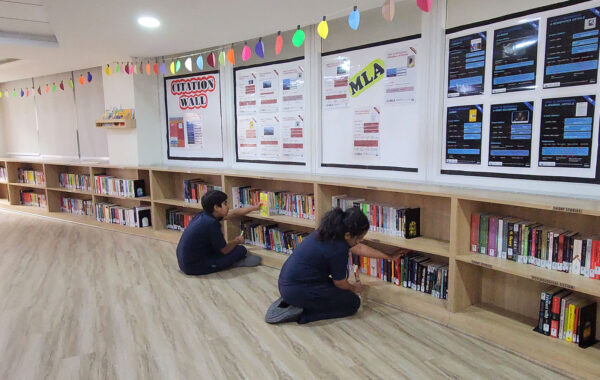 students exploring the shelves of the Secondary Library at Prometheus School, looking for books to read