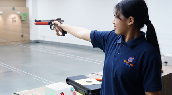 Dedicated practice: A Prometheus School girl hones her skills with focused pistol shooting practice at the range.