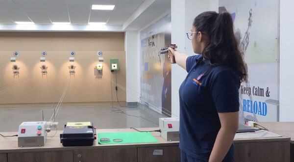 Focused aim: A Prometheus School girl performs pistol shooting with precision at the shooting range