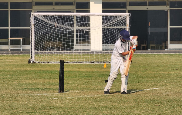 Batting defence-Prometheus school batsman swings the bat skilfully to defend the ball, demonstrating sharp reflexes