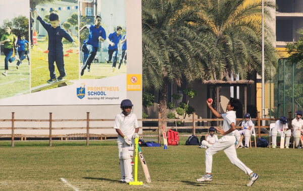 Fast-paced bowling- Prometheus school bowler delivers a fast-paced ball while the non-striker observes the action attentively
