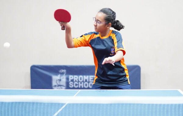 Focused gameplay-A Prometheus School girl strikes the ball with precision using her table tennis racquet