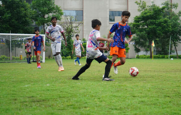 Intense tournament action-Students from Prometheus School engage in a high-energy interschool football tournament as the goalkeeper positions to save a goal