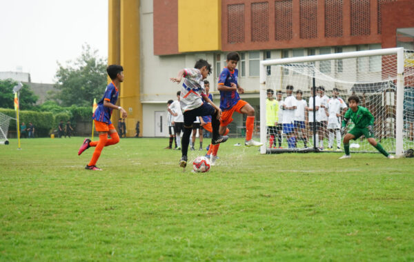 Powerful strike-A Prometheus School student showcases skill by kicking the ball energetically during gameplay