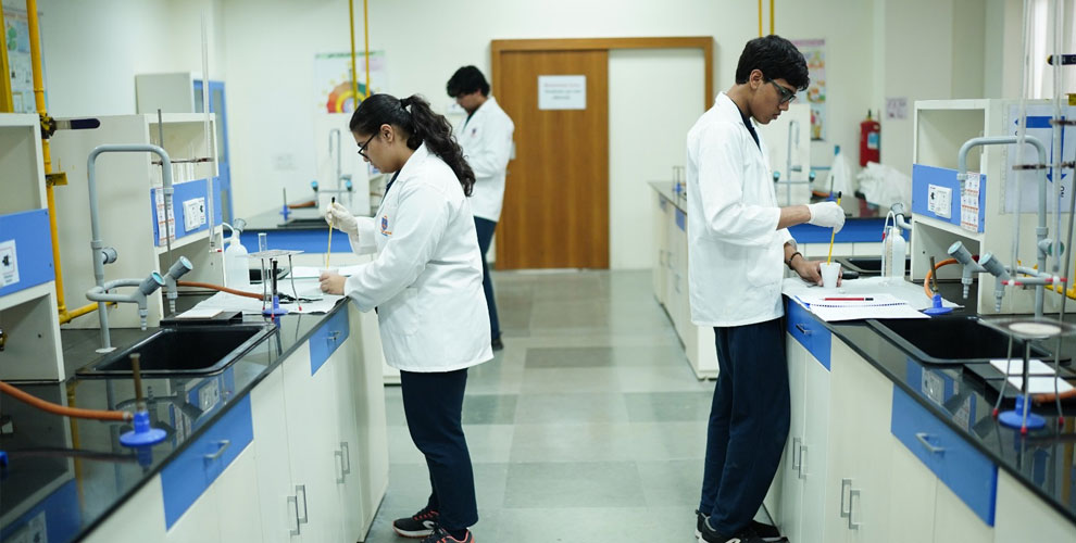 Exploring Science Through Experiments – Students actively engage in hands-on learning in the Chemistry lab, conducting experiments with precision and curiosity in a well-equipped scientific environment.