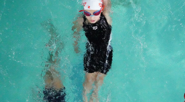 Synchronized effort: Prometheus School girls perform the backstroke together, highlighting teamwork and skill