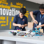 Innovative Robotics in Action – Prometheus School students collaborate in the robotics lab, assembling and programming a robot, showcasing their creativity and problem-solving skills